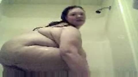 This huge fat woman masturbates in the shower