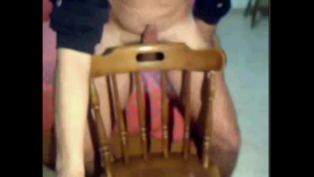 Pushing his dick through the chair to cum